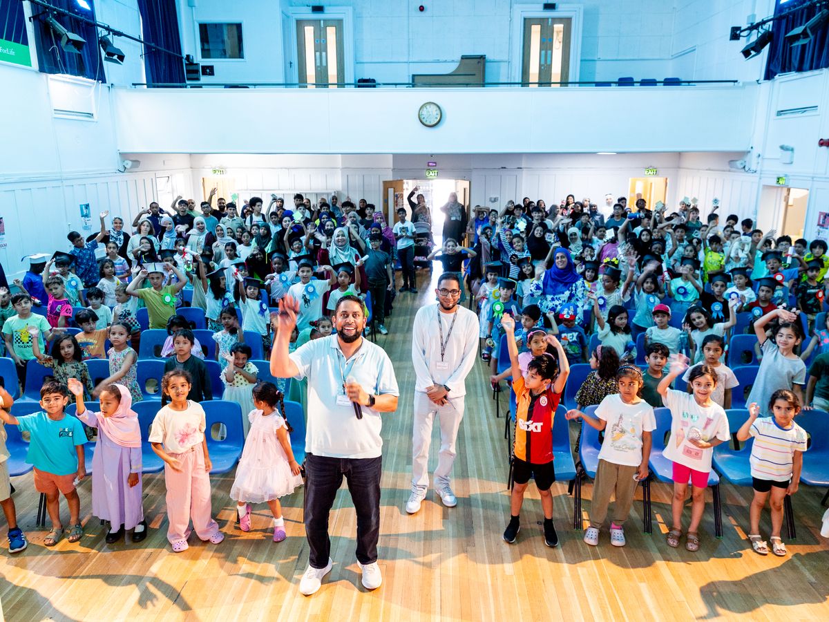 Hundreds of children, parents and teachers waving from their seats in the school hall at Verulam School.